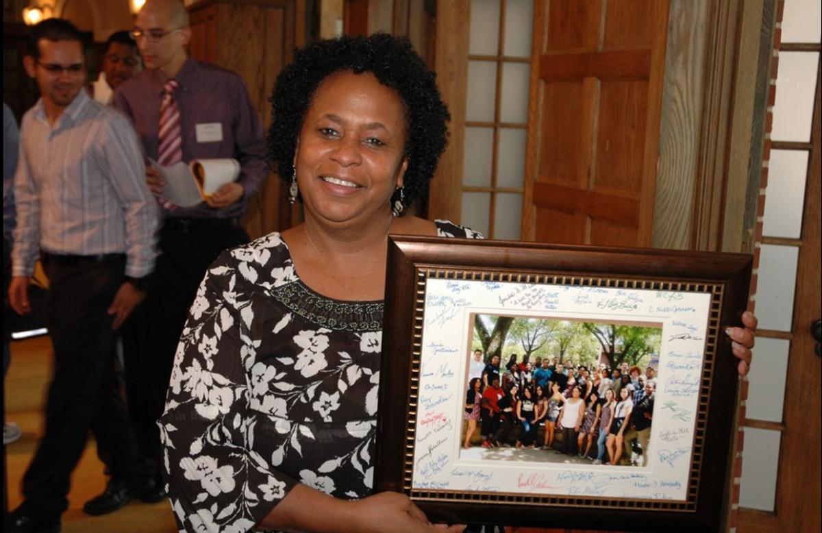 Diana Sproles poses with a signed photo from her SROP students.