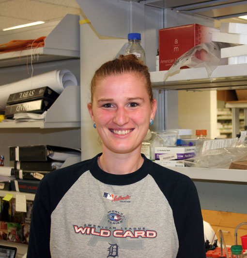 Diane McCabe stands in front of lab shelves and smiles.