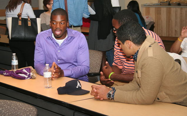 Sheehan Fisher (left), who earned his Ph.D. in clinical psychology at the University of Iowa in 2012, speaks with undergraduate students during the inaugural UI SROP Alumni Reunion in July, 2015.