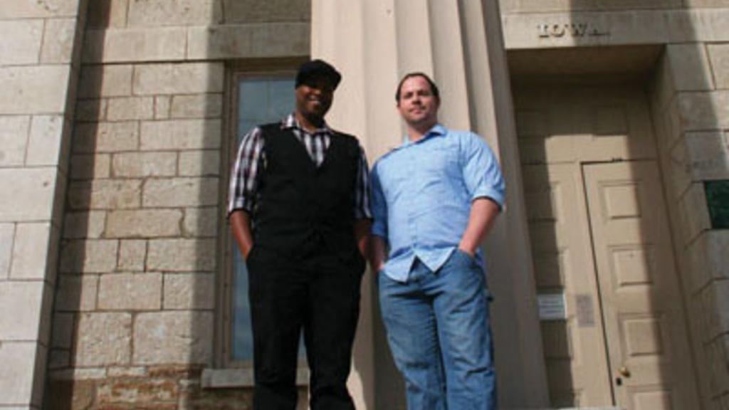 Nicholas Yanes and Derrais Carter stand in front of a building on the pentacrest