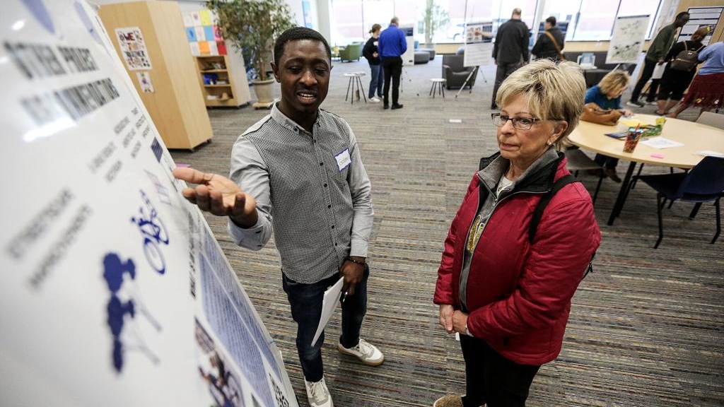 Gabriel Fordjour, a graduate student from University of Iowa’s School of Planning and Public Affairs, explains his ideas about public transportation to Deborah Schmidt, of Dubuque, during a public input session held at Multicultural Family Center on Saturday.